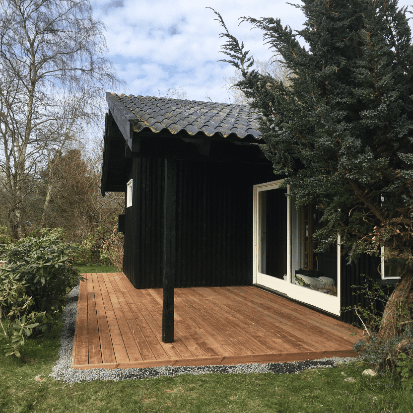 Træterrasse tilpasset et moderne sort sommerhus